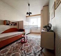 Interior of a 2-room apartment with carpeted floor, bed, and cabinet.