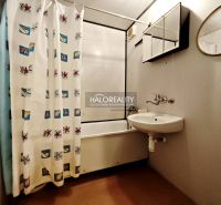 A bathroom in a 2-room apartment with a bathtub and a curtain, a sink with a mirror.