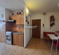 Kitchen in a 3-room apartment, floor with wooden decor, dining table, cabinets.