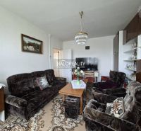 Living room in a 3-room apartment with a dark sofa set and carpet decor.