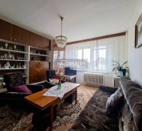 Living room in a 3-room apartment with comfortable furniture and a wall display cabinet.