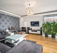Living room of a family house with wallpaper and wooden decor flooring.