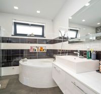 A bathroom in a family house with a corner bathtub and a large sink.