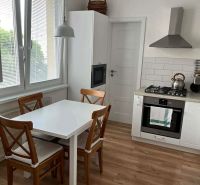 A kitchen in a 3-room apartment with a dining table and a wooden decor floor.