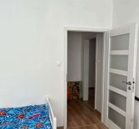 Children's room with a bed, white doors, and a floor with a wooden decor in a 3-room apartment.