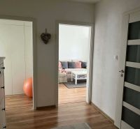 A hallway in a 3-room apartment with a wooden decor floor and a cozy interior.