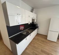 A kitchen in a 2-room apartment with a white kitchen unit and a floor with a wooden decor.