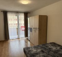 A room in a 2-room apartment with a bed, wardrobe, and a wooden decor floor.