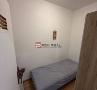 A single bed in a bedroom with wood-patterned flooring, 2-room apartment.