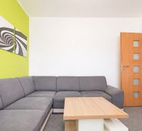 Living room with a corner sofa and a green wall in a 3-room apartment.