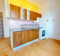 A kitchen with wooden decor in a 2-room apartment, light walls, built-in stove.