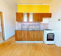 A kitchen in a 2-room apartment with a wooden decor countertop and floor.