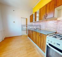 A kitchen in a 2-room apartment with a wooden decor floor and a gas stove.