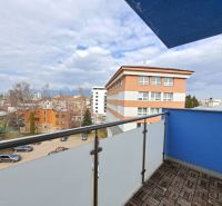 View from the balcony of a 3-room apartment in Poprad, parking, and surrounding architecture.
