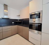 A modern kitchen in a 3-room apartment with beige cabinets and built-in appliances.