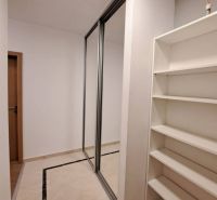 A hallway in a 3-room apartment with white walls, a built-in wardrobe, and a shelf.