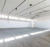 Spacious interior of warehouses and halls with concrete flooring and lighting.