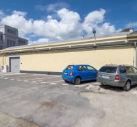 Parking lot near warehouses and halls on Coburgova Street in Trnava with several cars.
