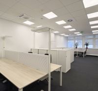Offices with wood-patterned flooring and work desks separated by partitions.