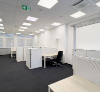 Offices with arranged desks and storage cabinets without decor.