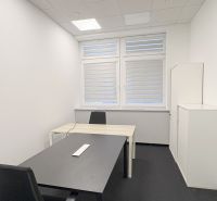 Offices with black carpet, two desks, and ceiling lighting.