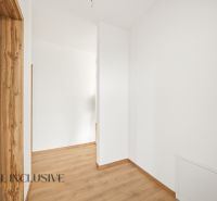 A hallway in a family house with white walls and a wooden decor floor.