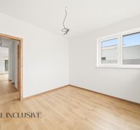 A room with a wooden decor floor in a family house, a bright room with a large window.