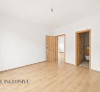 A room in a family house with a wooden decor floor and white walls.