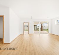 Interior of a family house with a wooden decor floor, open doors leading to the terrace.