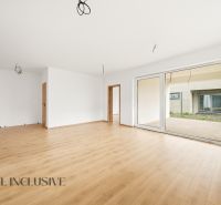 A spacious living room in a family house with a wooden decor floor and large doors to the garden.