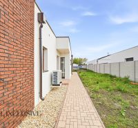 Exterior view of a family house in Dunajský Klátov with brick cladding and a grassy area.