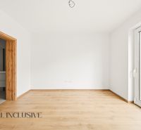 A room in a family house with a wooden decor floor and a spacious window.
