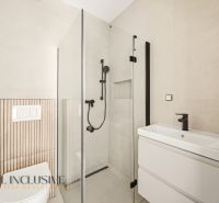 The bathroom of a family house with a modern shower and stylish white sanitary ceramics.