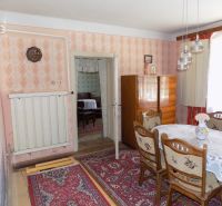 Dining room in a family house with carpet and dark wood furniture, decorative lighting fixtures.