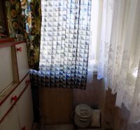 A family house with an antique dresser and curtains with a geometric pattern.