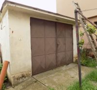 A garage at a family house in Strekov on Strekov Street with metal doors and a lawn.