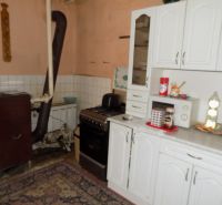 Kitchen with white cabinets and appliances in a family house.