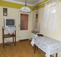 Living room with a television and a table, wooden decor flooring, family house.