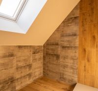 Attic bathroom with wood-patterned flooring and a skylight in a family house.