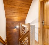 Wooden staircase with rope railing in a family house.