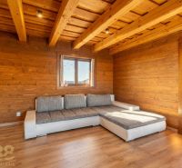 A family house with wooden cladding, a sofa, and a floor with a wooden design.