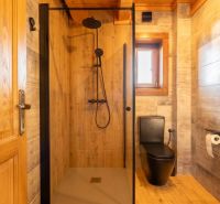 A bathroom in a family house with black sanitary equipment and a floor with a wood decor.