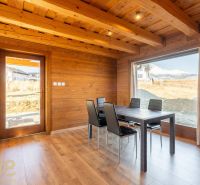 Dining area in a family house with a wooden decor floor and a view of the mountains.