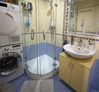 Bathroom with a shower, sink, washing machine, and dryer in a 4-room apartment.