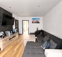 Living room with wood-patterned flooring, a sofa set, and a TV in a 3-room apartment.