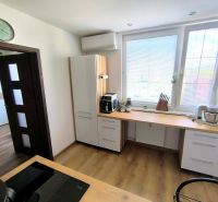 A kitchen in a 3-room apartment with light cabinets and a wooden-patterned floor.