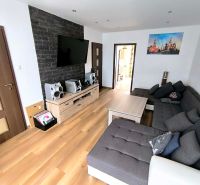 Living room with a sofa and wooden decor flooring in a 3-room apartment.