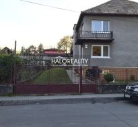 A family house in Poltár with a front garden and a car parked on the street.