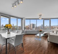Living room in a 3-room apartment with panoramic windows and a wooden decor floor.