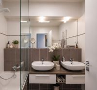 A bathroom with two sinks and a shower in a 3-room apartment, elegant design.